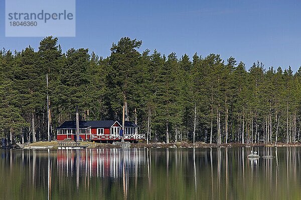 Schwedische rote Holzhütte am See im Frühling  Dalarna  Schweden  Europa
