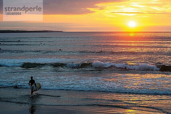 Mann mit Surfbrett stürzt sich bei Strandhill ins Wasser. Sligo  Irland  Europa