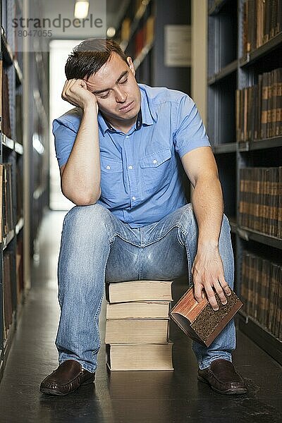 Student schläft in Bibliothek