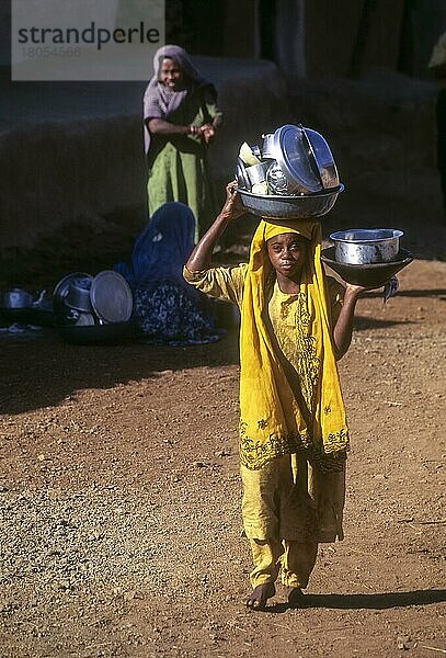 Habsi  Siddi Afrikanisches Stammesmädchen  das Haushaltsutensilien auf dem Kopf und in der Hand trägt  in Sasan Gir  Gujarat  Indien  Asien