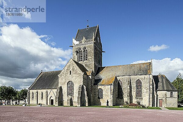 Kirche Sainte-Mère-Église mit Fallschirmdenkmal zu Ehren des Fallschirmjägers John Steele  der während des D-Day auf der Kirchturmspitze gefangen war  Normandie  Frankreich  Europa