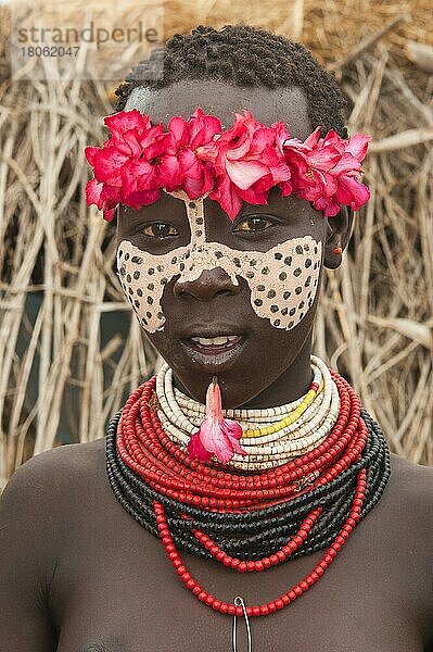 Karo-Mädchen mit Blumenkranz  Gesichtsbemalung  bunten Halsketten und Lippenpiercing  Omo-Tal  Südäthiopien  Karo