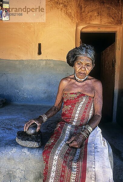 Alte Frau vom Stamm der Mudunga  vor der Hütte sitzend  gebrochene Betelnuss mit Stein  ein Stammesdorf in der Nähe des Silent Valley  Kerala  Indien  Asien