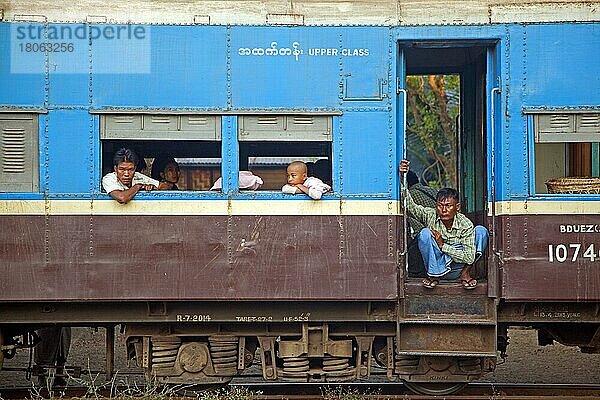 Birmesische Passagiere im blauen Oberklassewagen eines alten britischen Zuges in Myanmar  Burma