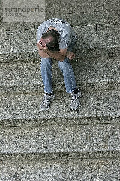 Verzweifelt wirkender Mann sitzt mit aufgestützten Armen auf Treppe  Verzweiflung  Alkoholsucht  Deutschland  Europa