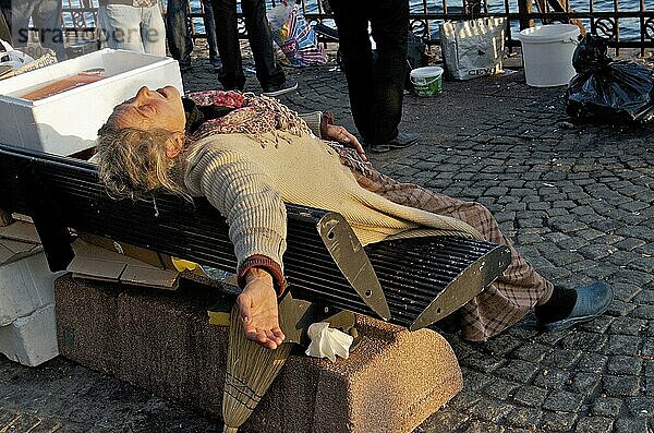 Schlafende obdachlose Frau schläft mit ausgestrecktem Arm auf Stadtbank  Istanbul  Türkei  Asien