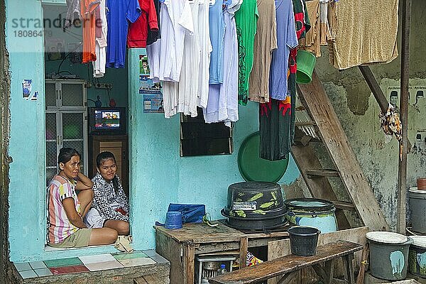 Indonesische Mutter und Tochter zu Hause mit Wäsche trocknend auf Wäscheleine in Kota  Old Batavia  Java  Indonesien  Asien