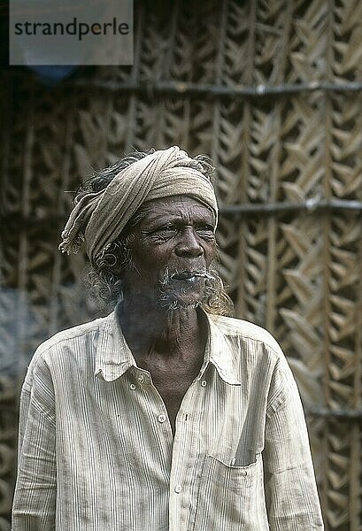 Ein Kurumba-Stammesangehöriger raucht Zedernholz  Anaikatty  Tamil Nadu  Indien  Asien