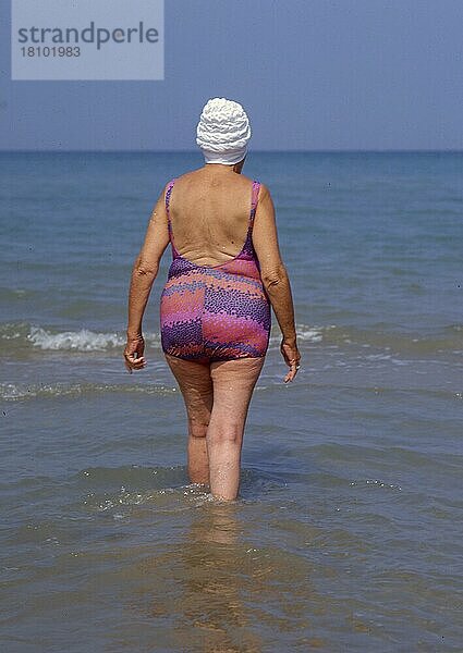 Ältere Frau geht in das Meer zum baden  schwimmen Old person woman goes swimming in the sea to  swim