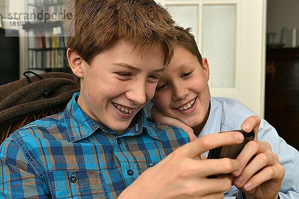 Jungen spielen Handyspiele  senden eine SMS  simsen