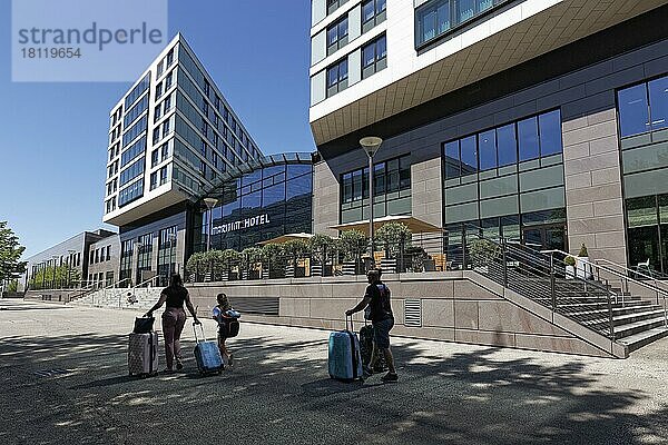 Familie mit Rollkoffer geht zum Maritim Hotel am Flughafen  Düsseldorf  Nordrhein-Westfalen  Deutschland  Europa