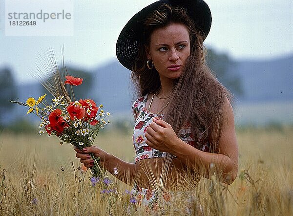 Junge Frau im Kornfeld Blumenstrauß