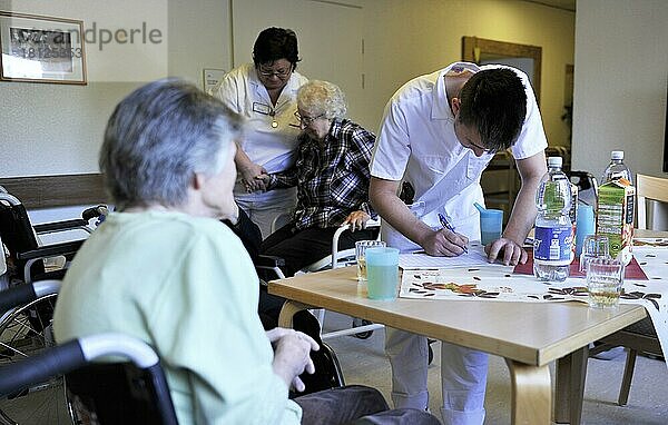 Vorbildliche Betreuung in Altenheimen  wie hier im Seniorenzentrum der Arbeiterwohlfahrt (AWO)  ist nicht überall anzutreffen. Die freundliche Zuneigung des Personals und die gut gestalteten lichtdurchfluteten Raeume schaffen eine angenehme Atmosphaere fuer die Senioren. Gewichtskontrolle bei den Senioren oftmals schwere Arbeit der Altenpfleger.  Deutschland  Europa