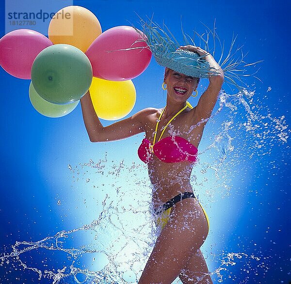 Junge Frau am Strand mit Luftballons