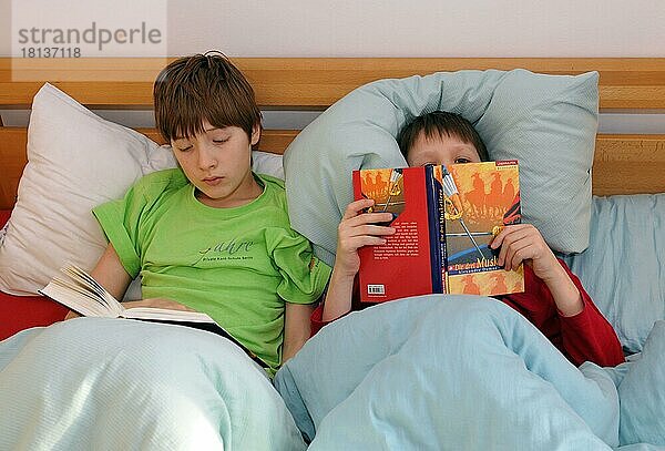 Kinder lesen Bücher im Bett