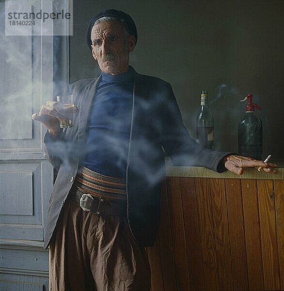 Alter Mann trinkt und raucht