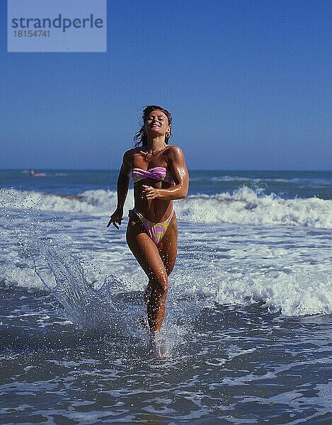 Junge Frau laufend am Strand