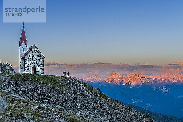 Mann genießt den Sonnenuntergang über den Dolomiten bei der Wallfahrtskirche von Lazfons  Klausen  Bezirk Bozen  Südtirol  Italien  Europa