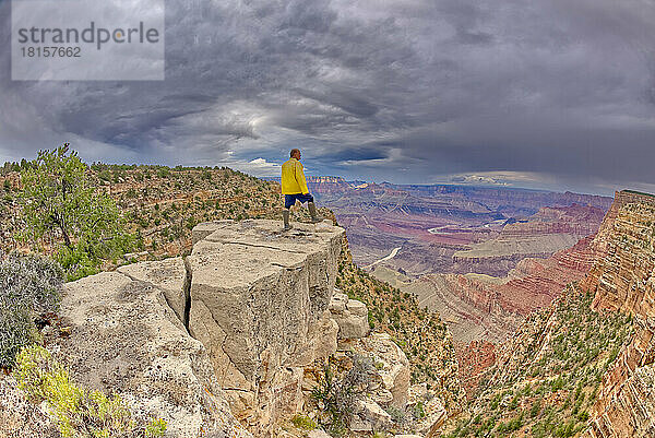 Ein Wanderer steht an einem stürmischen Tag auf einer Klippe zwischen Zuni und Papago Points am Grand Canyon  Grand Canyon National Park  UNESCO-Weltkulturerbe  Arizona  Vereinigte Staaten von Amerika  Nordamerika