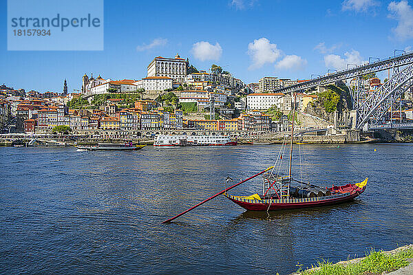 Blick auf die Brücke Dom Luis I. über den Fluss Douro und das Rabelo-Boot  ausgerichtet auf bunte Gebäude  UNESCO-Weltkulturerbe  Porto  Norte  Portugal  Europa
