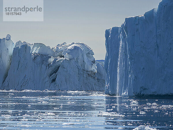 Ein Wasserfall aus schmelzenden Eisbergen aus dem Ilulissat-Eisfjord kurz vor der Stadt Ilulissat  Grönland  Dänemark  Polarregionen