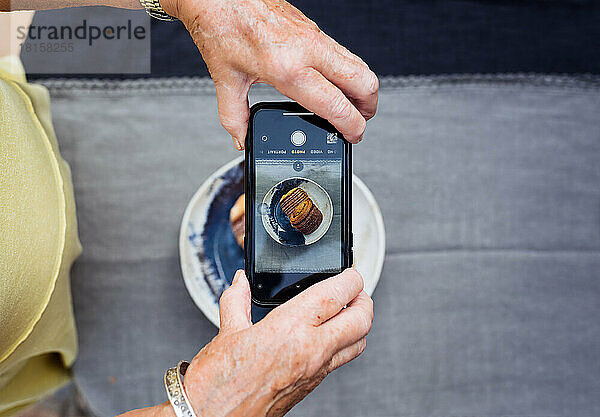 Rentnerin  die ihr Essen mit dem Handy fotografiert