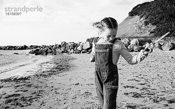 Schwarz-Weiß-Bild von Mädchen spielen und Ball am Strand