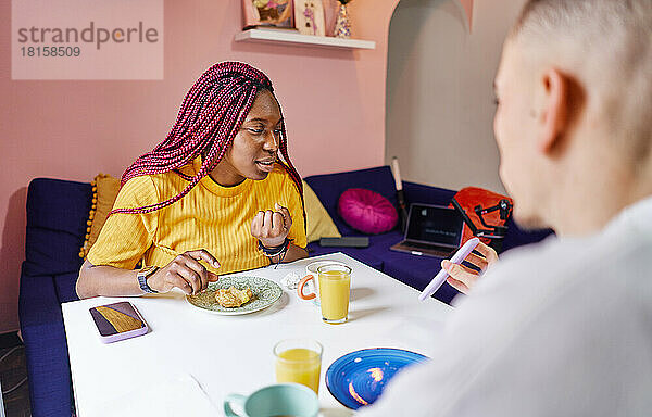 Glückliches multiethnisches Paar beim Frühstück zu Hause