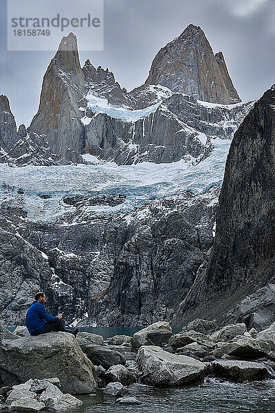 Junger Mann beim Ausruhen mit Blick auf den Mount Fitz Roy