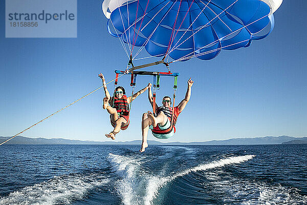 Ein Mann und eine Frau genießen das Parasailing in South Lake Tahoe  Kalifornien.