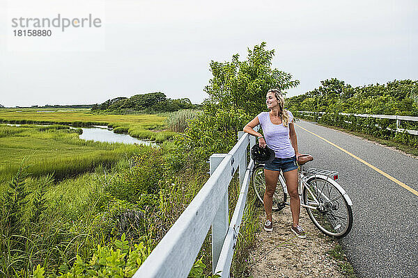 Frau rastet auf dem Radweg durch die Cape Cod Marshes