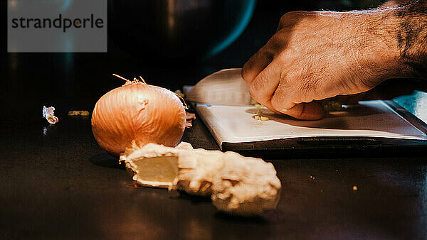 Mann schneidet Zwiebel in einer Küche