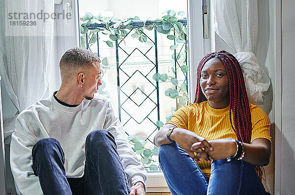 Glückliche afrikanische Freundin und Freund im Gespräch zu Hause