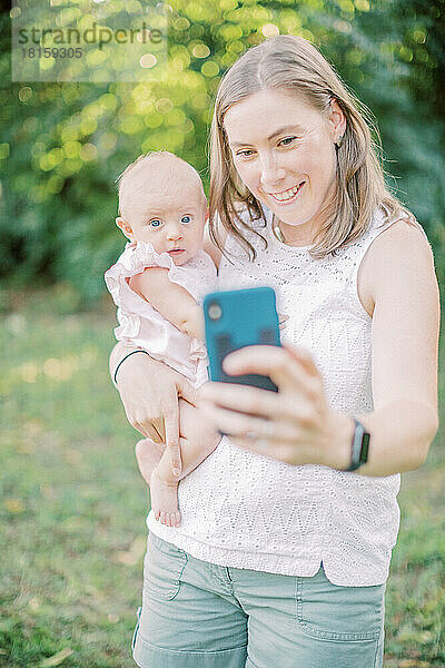 Eine 30-35 Jahre alte kaukasische Mutter macht ein Selfie mit ihrem 4 Monate alten Kind.