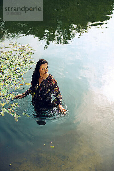 Ein Mädchen in einem schönen Kleid im Wasser