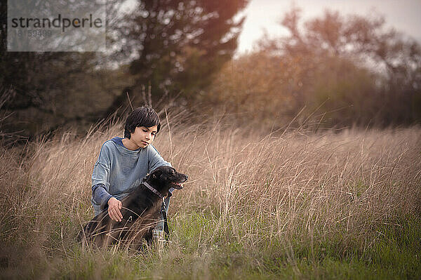 Ein Junge und sein Hund auf einem Feld