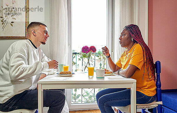 Ehepaar beim Frühstück am Tisch sitzend zu Hause