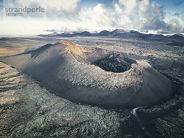 Schwarzer Vulkan über Lavafeldern aus der Vogelperspektive