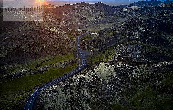 Kurvenreiche Straße in den Bergen bei Sonnenuntergang