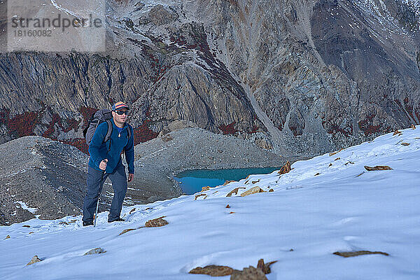 Mann allein beim Besteigen eines verschneiten Berges in Patagonien  Argentinien