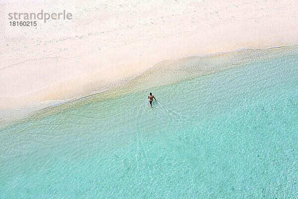 Luftaufnahme eines einsamen Mannes am Strand