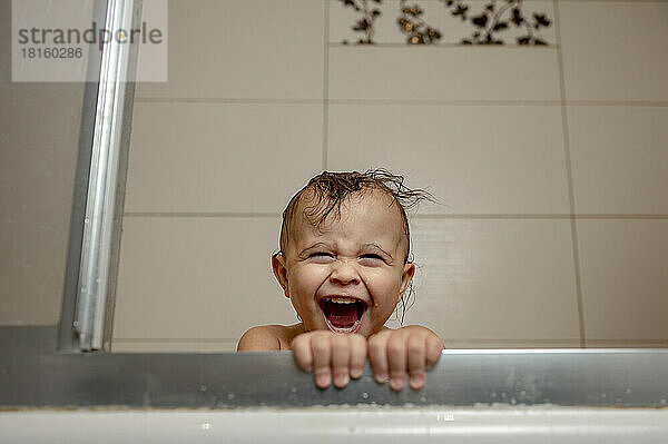 Baby boy shouting in bathtub
