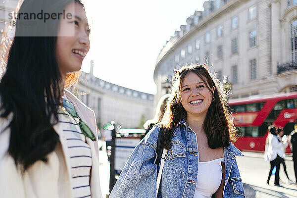 Happy lesbian friends strolling in city