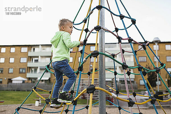 Junge klettert Seil im Park