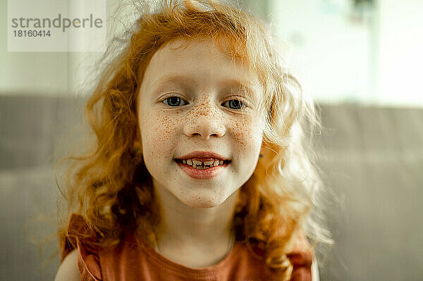 Lächelndes rothaariges Mädchen mit Sommersprossen