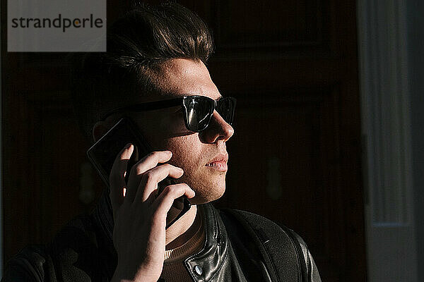Young man wearing sunglasses talking on mobile phone