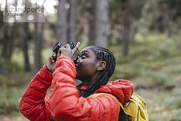 Junge Frau mit geflochtenem Haar fotografiert im Wald