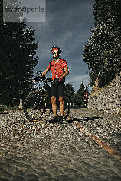 Radfahrer steht mit Fahrrad am Gotthardpass