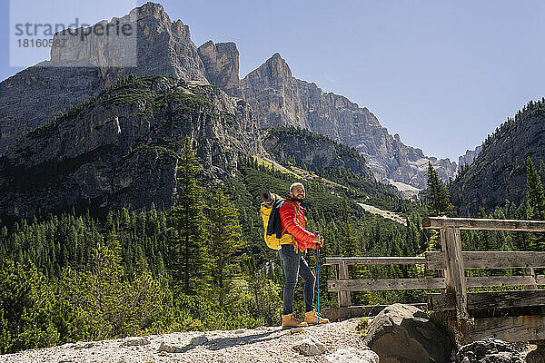 Wanderer mit Rucksack steht vor den Dolomiten  Italien