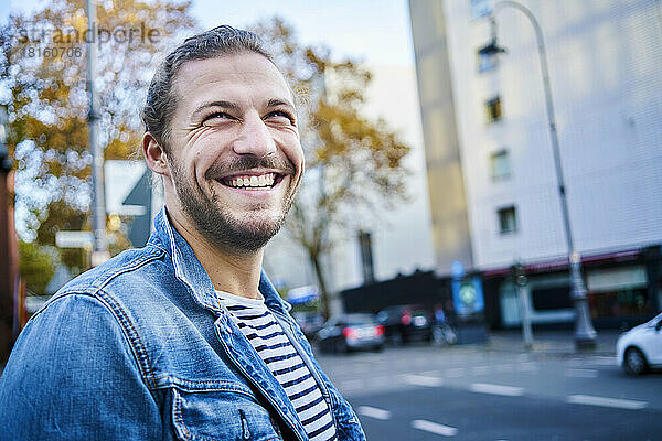 Portrait of bearded young man in the city laughing